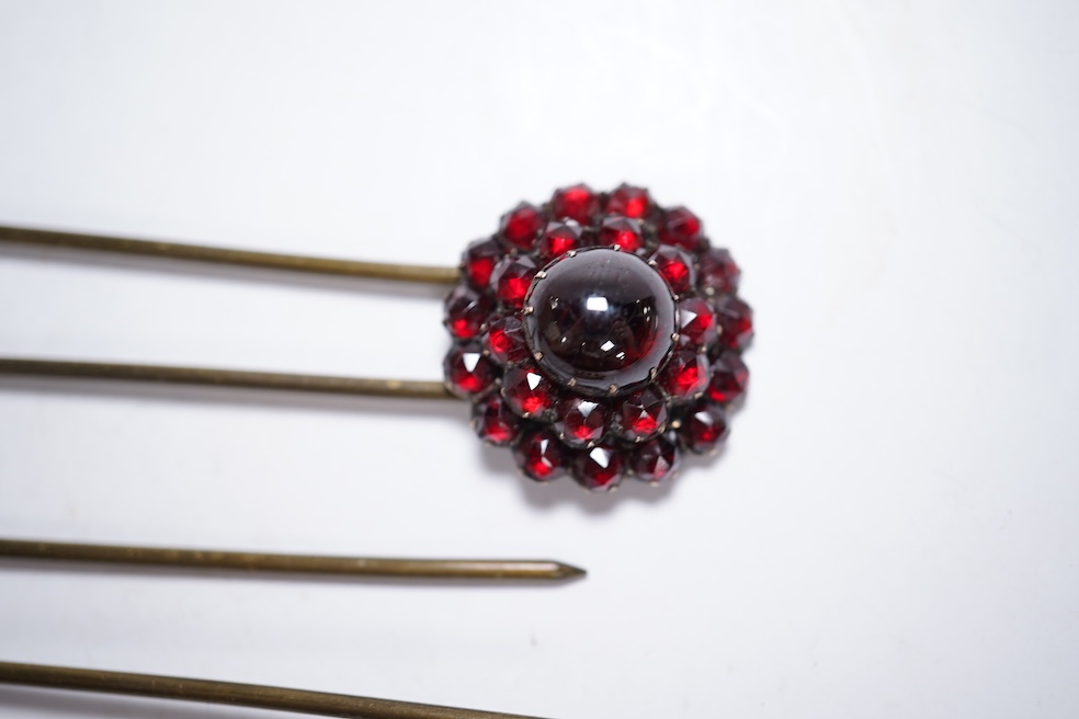 A Victorian yellow metal and garnet cluster set open work brooch, 27mm, together with two garnet cluster set hair ornaments. Condition - poor to fair